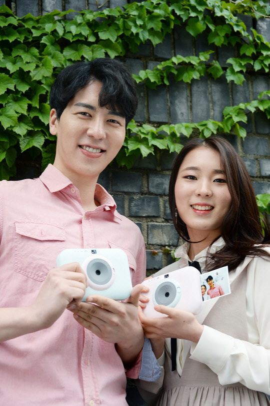 LG전자가 즉석카메라와 모바일 포토프린터를 합친 '포켓포토 스냅(PC389)'을 출시한다고 30일 밝혔다. 모델들이 제품을 소개하고 있다. <LG전자 제공>